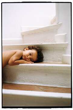 Portrait of Cute little boy with curly dart hair resting at home