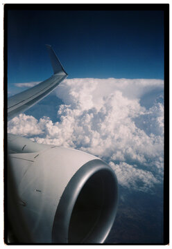 View above the clouds and blue sky from the window of an airplane