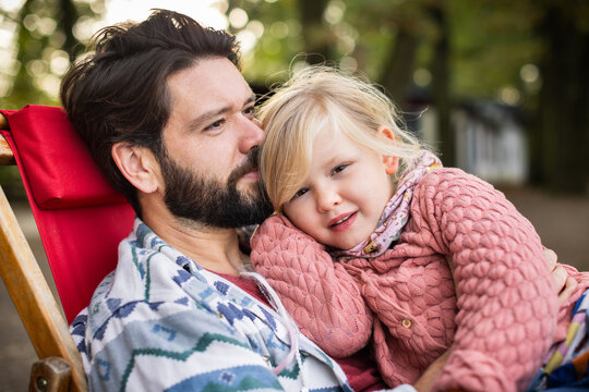 Tender Father and Daughter Cuddling During a Peaceful Outdoor Break