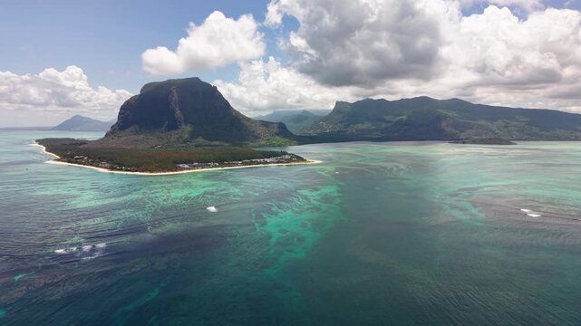 Bird's eye view of tropical island peninsula with dramatic basalt mountain and crystal clear turquoise waters. Mauritius Le Morne Brabant