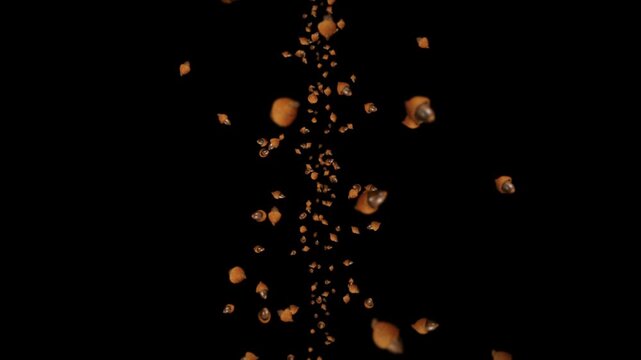 Small brown shells or seeds falling in a vertical stream against a black background