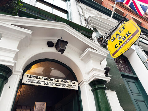 Manchester The Vine Inn pub exterior with yellow sign over arched doorway and Union flag decorations