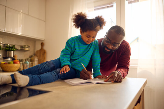 Father helps his child with schoolwork