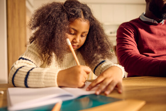 Little girl doing homework in the kitchen