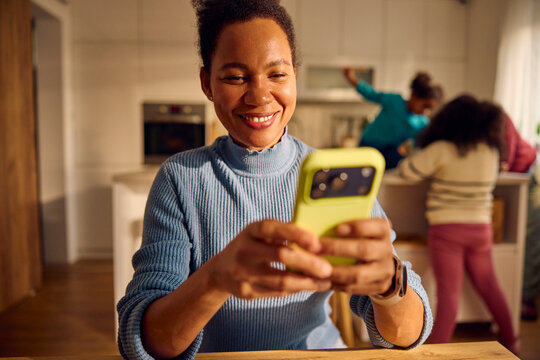 Happy woman stares at her phone in the kitchen