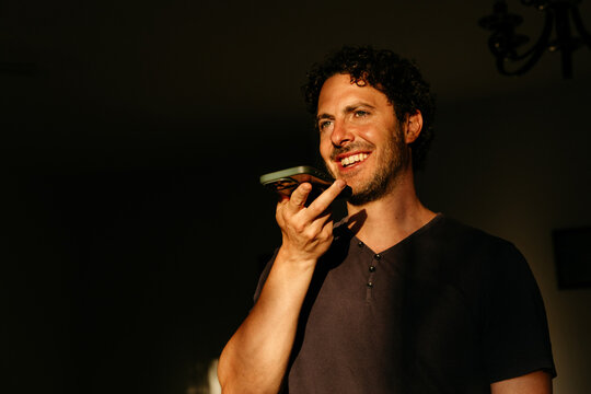 Man smiling speaking into smartphone