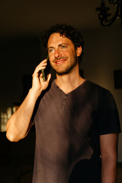 Young man smiling during phone call indoors