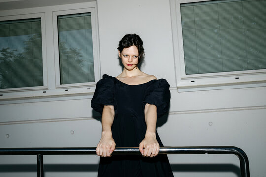 Woman holding railing in black puff dress