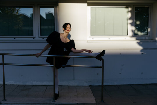 Woman stretching leg on railing