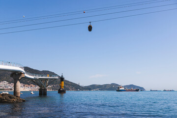 Busan Air Cruise, Busan cable car, ride on multicoloured sky capsule gondola route, with Songdo beach and Skywalk and Busan Bay panorama, South Korea, Songdo Station in a spring sunny day © tsuguliev
