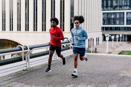 Runners training side by side as they move through pedestrian paths