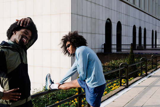 People stretching side by side framed by modern office buildings