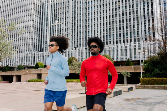 Male runners moving steadily through a modern corporate city