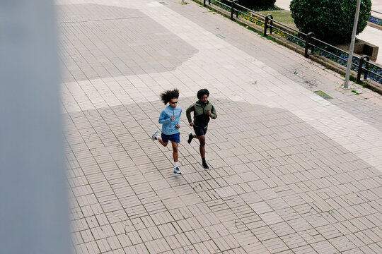 Aerial shot of two male athletes training on a pedestrian street