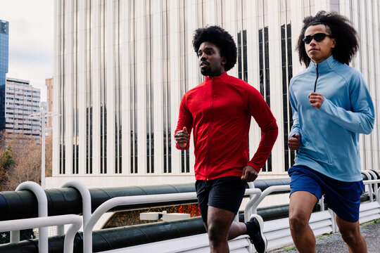 Athletes running through Madrid&rsquo;s city center, surrounded by buildings