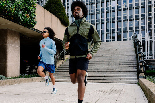 Male runners training in contemporary corporate architecture
