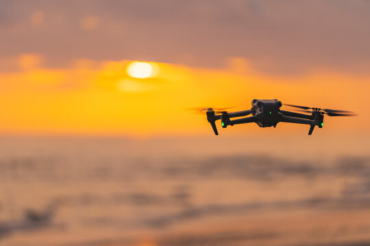 Drone hovering against a golden sunset