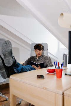 Entrepreneur pausing remote work leaning back with feet on the desk