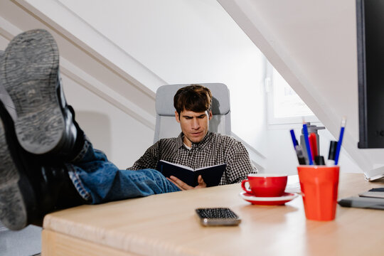 Freelance man taking a break at his home office desk