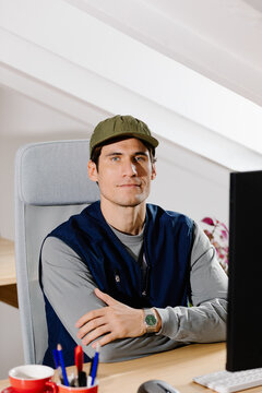 Portrait of a freelancer sitting at a home workspace facing the camera