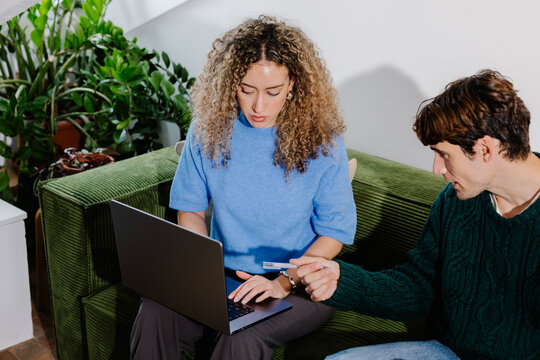 A freelance couple discussing a project, sitting on a sofa