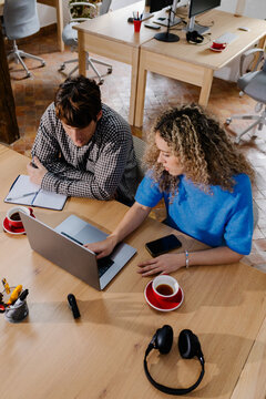 Overhead view of two self-employed individuals in a quiet home office