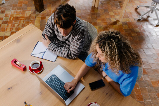 Overhead view of self employed people checking content on a computer