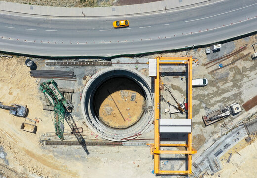 Aerial View of Deep Construction Shaft, Giant Crane and Urban Road