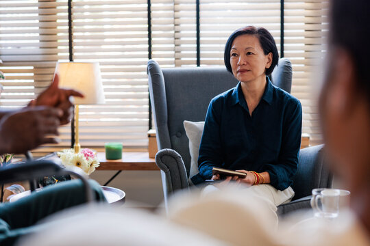 Woman in therapy session, listening intently.