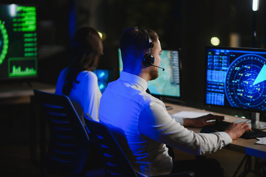 Air traffic controllers managing flight paths at night