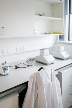 White Coat Hanging On The Chair Backrest At Lab Workspace
