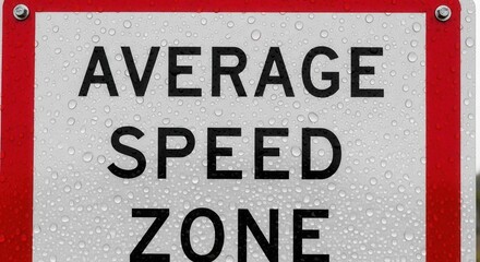 Obraz premium Average Speed Zone Sign Displaying Traffic Regulations in Wet Weather Conditions