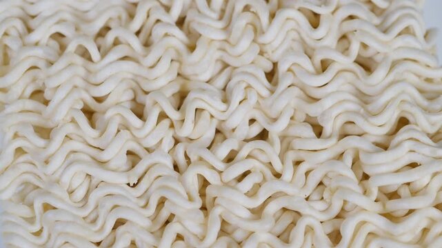 Close examination showcasing raw and uncooked ramen spaghetti strands. Detailed macro shot highlighting intricate textures of uncooked ramen noodle strands in their raw state