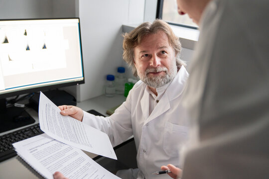 Junior and Senior Scientists Discuss Research Findings in Lab