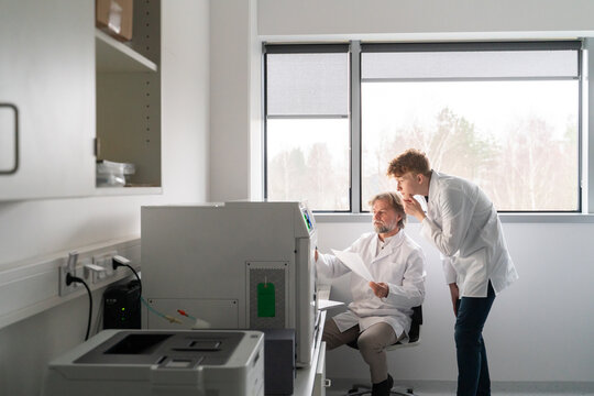 Senior And Junior Scientists Conversation In The Lab