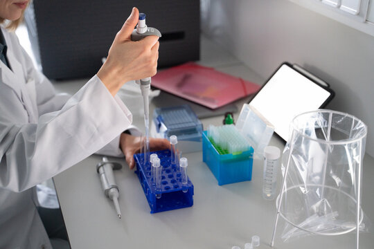 Researcher Using Pipette in Laboratory Setting