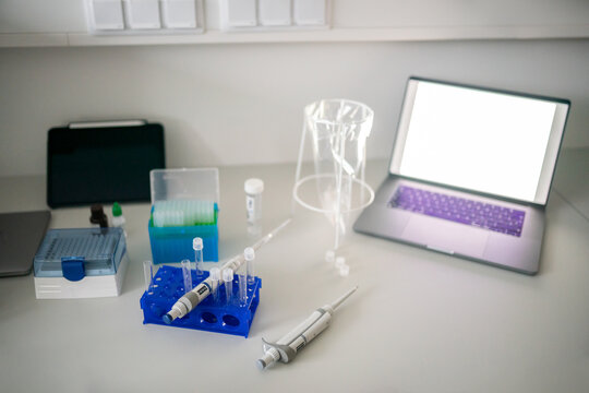 Desk With Computer, Tablet and Equipment in Lab Setting