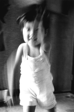 Blurred motion of child dancing indoors
