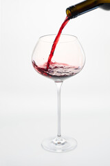 Red wine pouring from bottle into glass