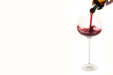Pouring red wine creating dynamic splash in elegant glass