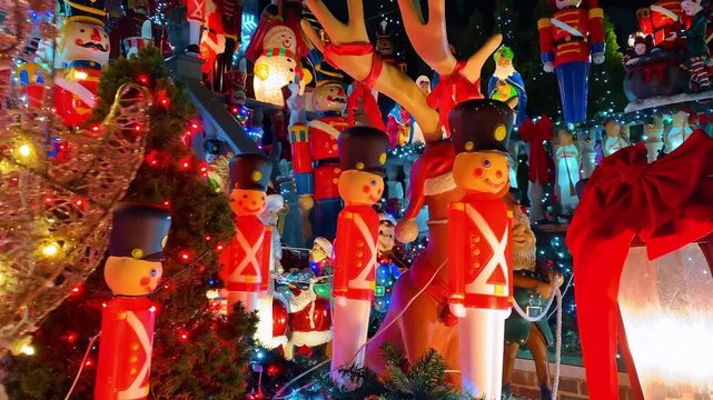 Christmas nutcracker and reindeer decorations with holiday lights. Close up of plastic soldier nutcrackers and reindeer figures illuminated by colorful lights.