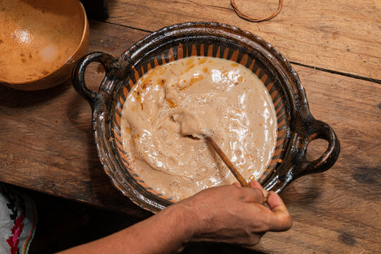 Mixing traditional cacao beverage in a rustic bowl