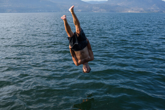 Person Diving Head First Lake From Standing Position in Sunny Weather