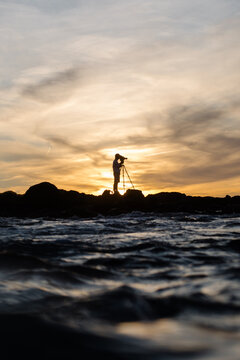 Outline of a videographer capturing footage of the sea