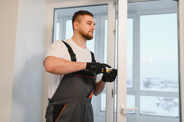 Worker fixing upvc window frame using a screwdriver