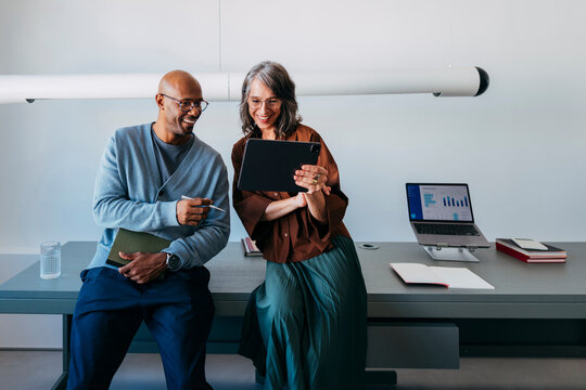 Happy Business Partners Review Tablet During Office Session