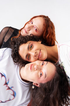 Three young women smiling in colorful fashion studio portrait