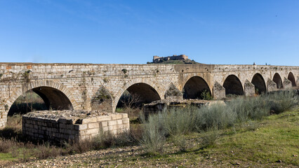 Fototapeta premium Ancient historic Roman bridge over the Guadiana river in Medellin Spain ESP