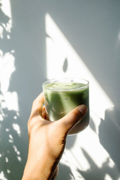 Hand holding cup of iced matcha