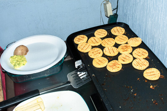 Cooking Tortillas and Preparing Guacamole in a Kitchen Setting